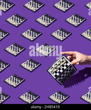 Motif damier sans couture sur un arrière-plan violet monochrome.La main femelle tient la planche d'échecs inclinée vers la droite.Échiquier noir et blanc.T Banque D'Images