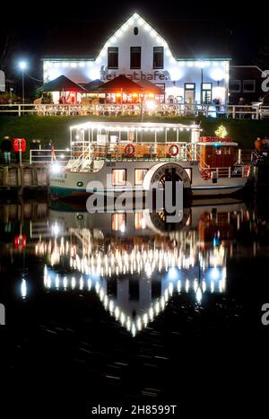 Carolinensiel, Allemagne.27 novembre 2021.Le bateau à aubes historique « Concordia II » est amarré dans le port historique avec des lumières de Noël.Depuis 1995, un arbre de Noël flottant a été traditionnellement érigé et les lumières allumées à Carolinensiel le samedi précédant le premier dimanche de l'Avent.Credit: Hauke-Christian Dittrich/dpa/Alay Live News Banque D'Images