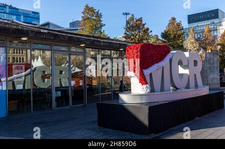 MCR avec chapeau de père Noël et abeille dorée de Manchester sur l'exposition avec relflection de fenêtre à Piccadilly Gardens, Manchester, Angleterre, Royaume-Uni.2021 Banque D'Images