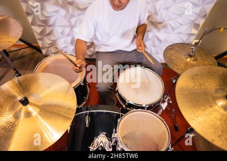 un batteur avec des pilons aime battre tout en jouant à la batterie Banque D'Images