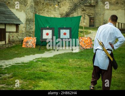 Personnes en vêtements médiévaux avec des arcs sur le territoire du château Banque D'Images