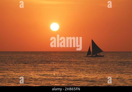 Coucher de soleil à Boracay offre un coucher de soleil grandiose sur la plage de Boracay.Une façon de se détendre après une journée passée à profiter de l'atmosphère tropicale de l'île. Banque D'Images
