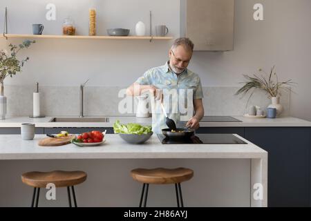 Homme de cuisine originaire des années 60 dans la cuisine Banque D'Images