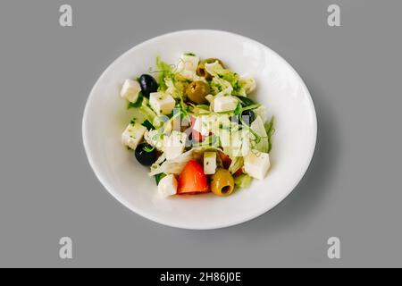 Salade grecque sur fond gris Uni.Microgreen frais sur salade.Vue avant. Banque D'Images