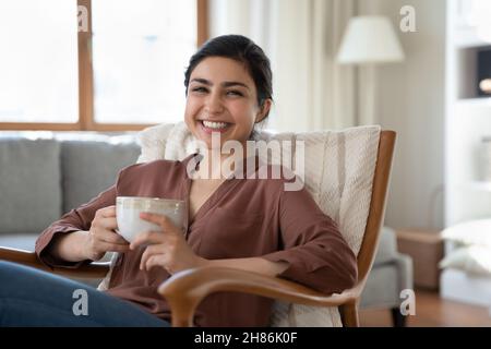 Portrait d'une femme indienne souriante avec une tasse de thé. Banque D'Images