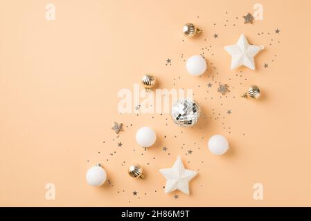 Vue du dessus photo de la composition de rangée blanc et or décorations d'arbre de noël boules disco étoiles brillantes et paillettes sur un arrière-plan beige isolé avec em Banque D'Images