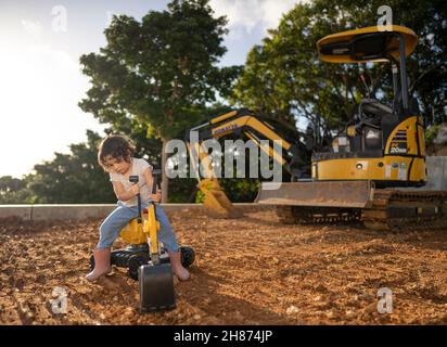 une jeune fille de 3 ans joue avec un jouet de digger Banque D'Images