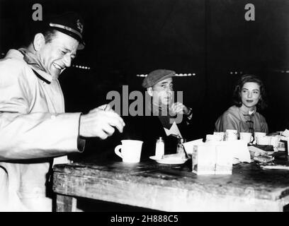 HUMPHREY BOGART en visite à son épouse LAUREN BACALL et JOHN WAYNE sur place Candid pendant le tournage de BLOOD ALLEY 1955 réalisateur WILLIAM A. WELLMAN Batjac Productions / Warner Bros. Banque D'Images