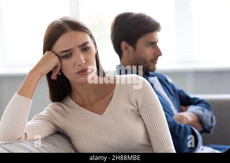 Portrait de la triste jeune femme européenne offense ignore mari malheureux après querelle dans le salon intérieur Banque D'Images