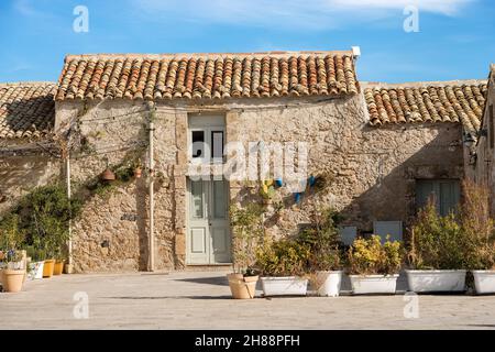 Petite maison typique construite avec des pierres dans l'ancien village de pêcheurs de Marzamemi près de Pachino, province de Syracuse, île de Sicile, Italie, Europe. Banque D'Images