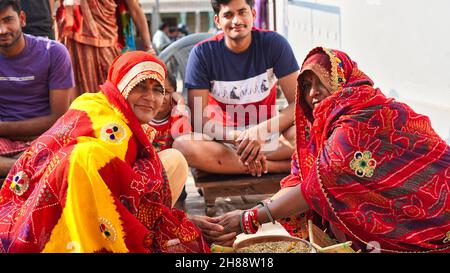 21 novembre 2021 Reengus, Rajasthan, Inde.Les femmes indiennes célèbrent le mariage de travail heureux assis devant le marié. Banque D'Images