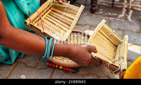 Deux femmes indiennes dans la cérémonie de mariage, les femmes célèbrent les rituels de mariage avec des choses saintes comme la graine de sorgho et le curcuma. Banque D'Images