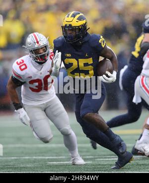 Ann Arbor, États-Unis.28 novembre 2021.Michigan Wolverines en arrière Hassan Haskins (25) passe devant le défenseur des Buckees de l'État de l'Ohio Cody Simon (30) lors d'une course à Ann Arbor, Michigan, le samedi 27 novembre 2021.Photo par Aaron Josefczyk/UPI crédit: UPI/Alay Live News Banque D'Images