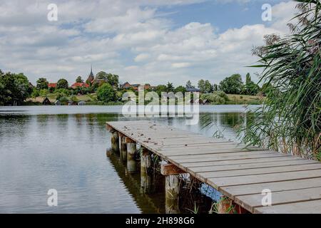 Idyllique sur la rive sud-ouest du lac de Plätlinsee se trouve le petit village de Wustrow.Sur la colline au-dessus du lac s'élève depuis 1896 une église en brique. Banque D'Images