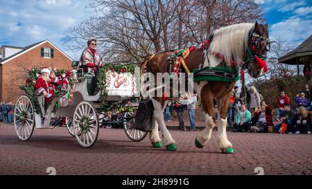 Saint-Charles, Mo—27 décembre 2021; l'acteur et l'actrice dépeignent le Père Noël et Mme Claus tout en agitant deux foules d'une calèche tirée par des chevaux dans le centre-ville de Noël Banque D'Images