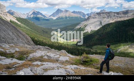 Randonneur mâle jouissant de la vue sur la vallée alpine à Kananaskis, Rocheuses canadiennes, Canada Banque D'Images