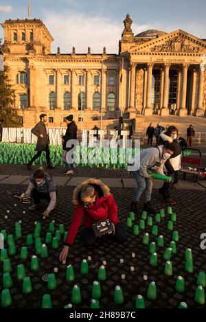 Berlin, Allemagne.28 novembre 2021.Feux verts devant le bâtiment Reichstag à Berlin, lieu de rencontre du Parlement allemand.Les résidents polonais près de la frontière biélorusse ont allumé des feux verts dans leurs maisons et leurs porches pour guider les migrants hors de la forêt et pour assurer leur sécurité.Manifestation à Berlin le 28 novembre 2021.(Photo de Jakub Podkowiak/PRESSCOV/Sipa USA) crédit: SIPA USA/Alay Live News Banque D'Images