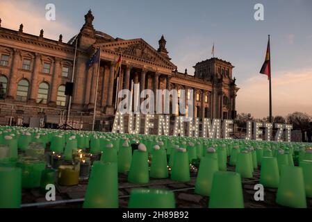 Berlin, Allemagne.28 novembre 2021.Feux verts devant le bâtiment Reichstag à Berlin, lieu de rencontre du Parlement allemand.Les résidents polonais près de la frontière biélorusse ont allumé des feux verts dans leurs maisons et leurs porches pour guider les migrants hors de la forêt et pour assurer leur sécurité.Manifestation à Berlin le 28 novembre 2021.(Photo de Jakub Podkowiak/PRESSCOV/Sipa USA) crédit: SIPA USA/Alay Live News Banque D'Images