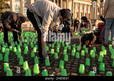 Berlin, Allemagne.28 novembre 2021.Feux verts devant le bâtiment Reichstag à Berlin, lieu de rencontre du Parlement allemand.Les résidents polonais près de la frontière biélorusse ont allumé des feux verts dans leurs maisons et leurs porches pour guider les migrants hors de la forêt et pour assurer leur sécurité.Manifestation à Berlin le 28 novembre 2021.(Image de crédit : © Jakub Podkowiak/PRESSCOV via ZUMA Press Wire) Banque D'Images
