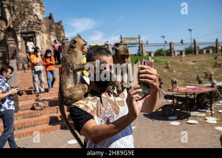 Lopuri, Thaïlande.28 novembre 2021.Un touriste prend des photos avec des singes lors du festival annuel des singes de Lophuri en Thaïlande.(Image de crédit : © Andre Malerba/ZUMA Press Wire) Banque D'Images