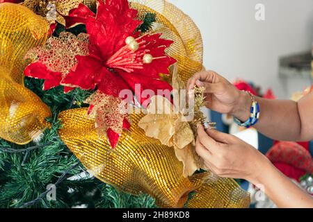 Les mains de la femme décorent l'arbre de Noël Banque D'Images