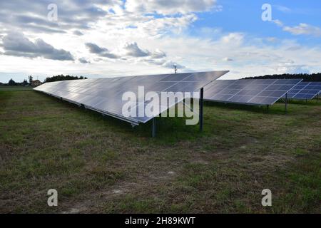 Les panneaux solaires montés au sol génèrent de l'électricité par temps nuageux.Nuages. Banque D'Images