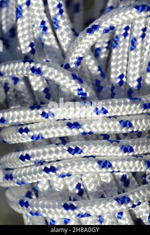 Gros plan et vue détaillée d'une corde en plastique spiralée avec des fibres blanches et bleues Banque D'Images