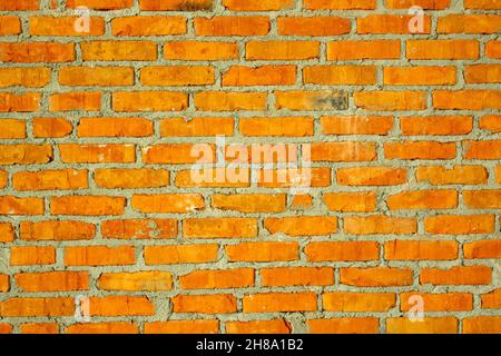 Mur en brique rouge avec joint de colle de ciment gris. Arrière-plan vintage créatif. Banque D'Images