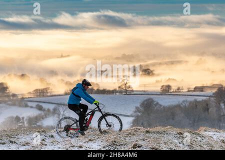 Ingleton, North Yorkshire, 28 novembre 2021.Keen Mountain Biker, ISACC Bargh, utilise le temps qui s'est installé après que la région a été frappée par Storm Arwen.Il est ici sur les pentes inférieures d'Ingleborough, l'un des célèbres 3 sommets, surplombant un Burton brumeux à Lonsdale.Crédit : Wayne HUTCHINSON/Alamy Live News Banque D'Images