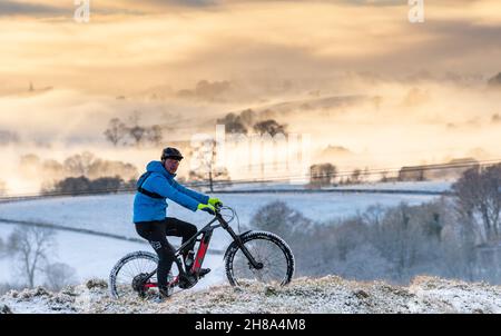 Ingleton, North Yorkshire, 28 novembre 2021.Keen Mountain Biker, ISACC Bargh, utilise le temps qui s'est installé après que la région a été frappée par Storm Arwen.Il est ici sur les pentes inférieures d'Ingleborough, l'un des célèbres 3 sommets, surplombant un Burton brumeux à Lonsdale.Crédit : Wayne HUTCHINSON/Alamy Live News Banque D'Images