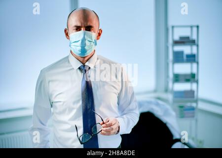 scientifique fatigué dans un masque de protection debout dans le laboratoire. photo avec un espace de copie. Banque D'Images