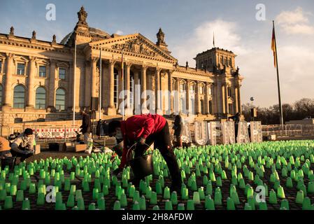 Berlin, Allemagne.28 novembre 2021.Feux verts devant le bâtiment Reichstag à Berlin, lieu de rencontre du Parlement allemand.Les résidents polonais près de la frontière biélorusse ont allumé des feux verts dans leurs maisons et leurs porches pour guider les migrants hors de la forêt et pour assurer leur sécurité.Manifestation à Berlin le 28 novembre 2021.(Image de crédit : © Jakub Podkowiak/PRESSCOV via ZUMA Press Wire) Banque D'Images
