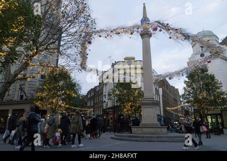 Londres, Royaume-Uni, 28 novembre 2021 : les acheteurs de Noël parmi les lumières de Noël dans le Covent Garden.Malgré les inquiétudes concernant la nouvelle variante du coronavirus et l'imposition imminente de règles de masque plus strictes en Angleterre à partir de mardi, la lure de Londres sur un dimanche après-midi ensoleillé a été attrayante pour les acheteurs.Des files d'attente se sont formées avec ceux qui espèrent obtenir une bonne affaire des offres du Black Friday qui sont encore en cours.Anna Watson/Alay Live News Banque D'Images