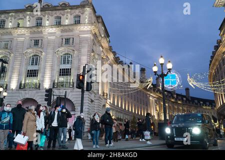 Londres, Royaume-Uni, 28 novembre 2021 : les amateurs de Noël font partie des lumières de Noël de Regent Street et de Picadilly Circus dans le West End de Londres.Malgré les inquiétudes concernant la nouvelle variante du coronavirus et l'imposition imminente de règles de masque plus strictes en Angleterre à partir de mardi, le charme de Londres lors d'un dimanche après-midi ensoleillé a été attrayant pour les acheteurs espérant faire une affaire avec les offres du Black Friday qui étaient encore en cours.Anna Watson/Alay Live News Banque D'Images