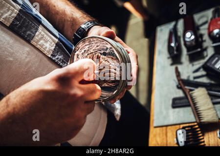 Coiffez dans le salon de coiffure pour préparer de la mousse à raser dans un bol à l'aide d'une brosse. Banque D'Images