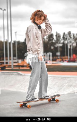 Fille sur le skateboard dans le parc l'après-midi Banque D'Images