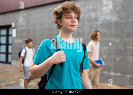 Un jeune garçon rentre à la maison après les cours scolaires Banque D'Images