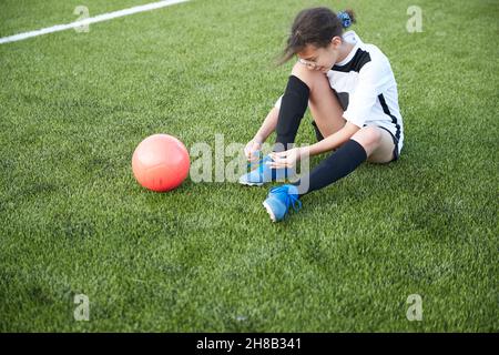 Royaume-Uni, une joueuse féminine de football noue des chaussures sur le terrain Banque D'Images
