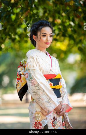 Femme portant un kimono debout dans le parc Banque D'Images