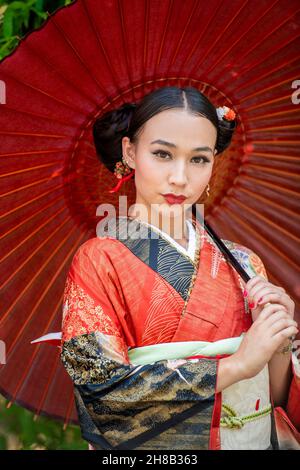 Portrait d'une femme portant un kimono et tenant un parasol Banque D'Images