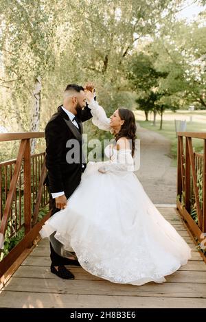 Mariée et marié sur la passerelle dans le parc Banque D'Images