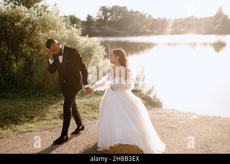 Mariée et marié marchant sur le bord du lac Banque D'Images