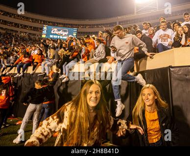 Stillwater, Oklahoma, États-Unis.27 novembre 2021.Les fans de cow-boy de l'État de l'Oklahoma se précipitent sur le terrain après la victoire de 37-33 sur les Oklahoma Sooners le samedi 27 novembre 2021 au stade Boone Pickens à Stillwater, Oklahoma.(Image de crédit : © Nicholas Rutledge/ZUMA Press Wire) Banque D'Images