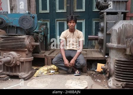 Au Chor Bazaar ou au marché des voleurs, un célèbre marché d'occasion à Mumbai, en Inde, un mécanicien se trouve entre de vieilles pièces de moteur Banque D'Images