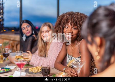 Amis discutant de la Saint-Sylvestre à une table décorative Banque D'Images