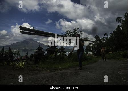 Bali Aga peuple actif vu à côté du temple du village de Terunyan avec le volcan Batur comme arrière-plan et épargné par le lac de l'emplacement du cimetière de Terunyan dans l'île de Bali, Indonésie.Photo prise le 3 novembre 2016.La tradition de crémation Terunyan est un patrimoine intangible de la tribu Bali Aga (indigène de l'île de Bali) qui s'adapta aux caractéristiques naturelles de l'anneau de feu du Pacifique à l'époque néolithique et encore préservé jusqu'à présent.L'uniqely de la tradition de crémation de Terunyan est au sujet de lacérer le corps de la mort sans burried à l'intérieur de la forêt d'encens végétation tache loin de la principale tache Banque D'Images