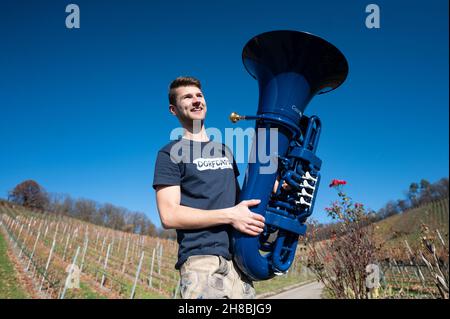 Brackenheim, Allemagne.23 novembre 2021.Micha, de Brackenheim, musicien portant le nom de scène 'Micha von der Rampe', se dresse dans les vignobles avec son tuba bleu.Il a raccroché un emploi dans la banque pour sa musique.Au lieu de porter un costume, il porte maintenant un pantalon en cuir et apporte une bouffée d'air frais à la scène pop avec son tuba bleu.(À dpa Un banquier avec un tuba bleu lors d'une visite du village) Credit: Marijan Murat/dpa/Alamy Live News Banque D'Images