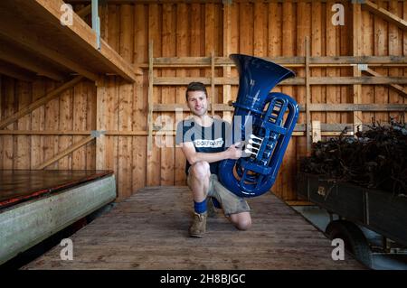 Brackenheim, Allemagne.23 novembre 2021.Micha, de Brackenheim, musicien portant le nom de scène 'Micha von der Rampe', tient son tuba bleu.Il a raccroché un emploi dans la banque pour sa musique.Au lieu de porter un costume, il vient maintenant dans un pantalon en cuir et apporte une bouffée d'air frais dans la scène pop avec son tuba bleu.Credit: Marijan Murat/dpa/Alamy Live News Banque D'Images