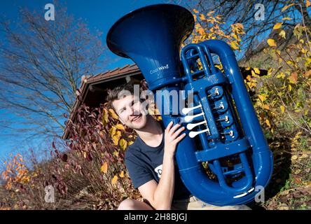 Brackenheim, Allemagne.23 novembre 2021.Micha, de Brackenheim, musicien portant le nom de scène 'Micha von der Rampe', tient son tuba bleu.Il a raccroché un emploi dans la banque pour sa musique.Au lieu de porter un costume, il vient maintenant dans un pantalon en cuir et apporte une bouffée d'air frais dans la scène pop avec son tuba bleu.Credit: Marijan Murat/dpa/Alamy Live News Banque D'Images