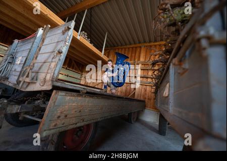 Brackenheim, Allemagne.23 novembre 2021.Micha, de Brackenheim, musicien portant le nom de scène 'Micha von der Rampe', tient son tuba bleu.Il a raccroché un emploi dans la banque pour sa musique.Au lieu de porter un costume, il vient maintenant dans un pantalon en cuir et apporte une bouffée d'air frais dans la scène pop avec son tuba bleu.Credit: Marijan Murat/dpa/Alamy Live News Banque D'Images